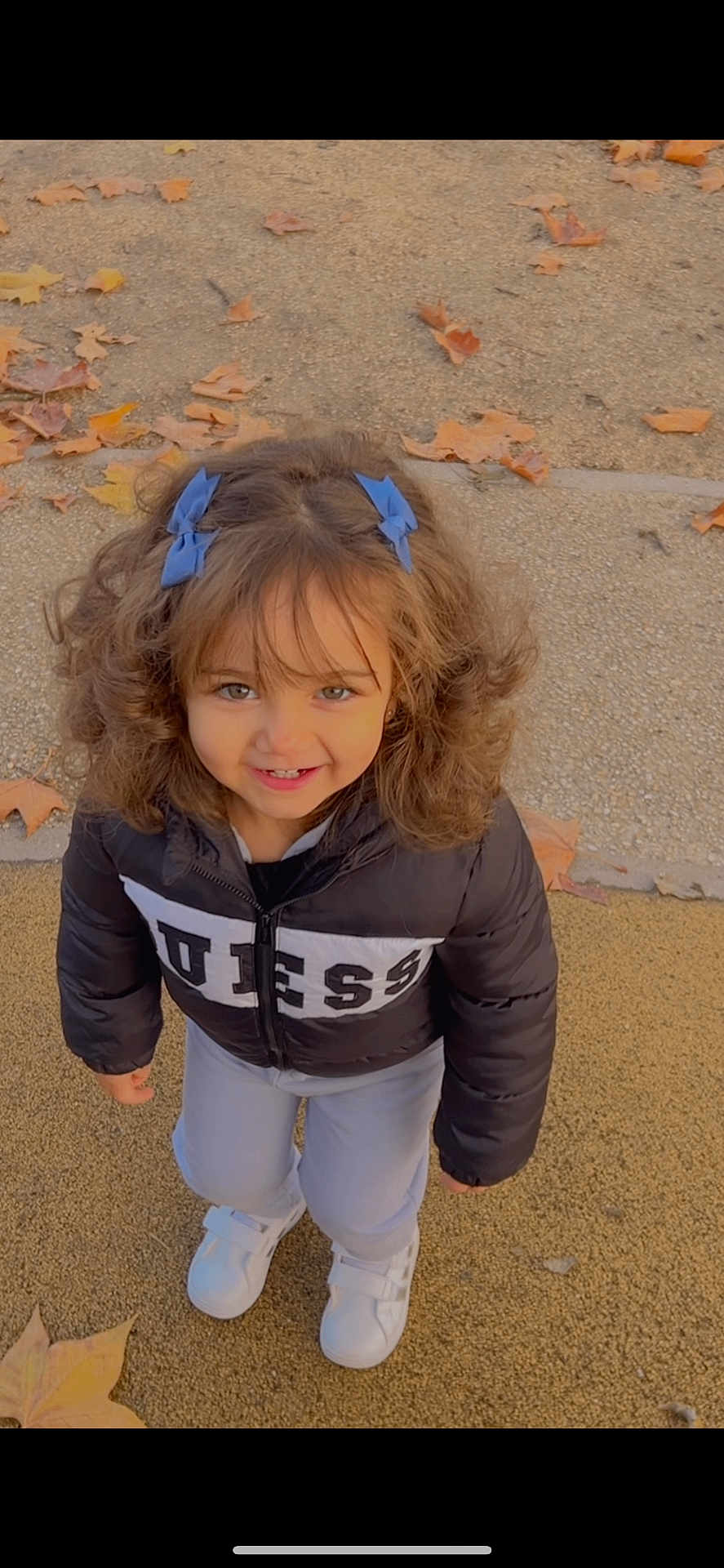 Layene a rejoint le concours — aidez-le/la à gagner de superbes lots ! child, girl, smiling, curly_hair, blue_bows, jacket, white_shoes, outdoor, autumn, leaves, ground, happy, portrait, cute, fashion, person, young, standing, casual, playful
