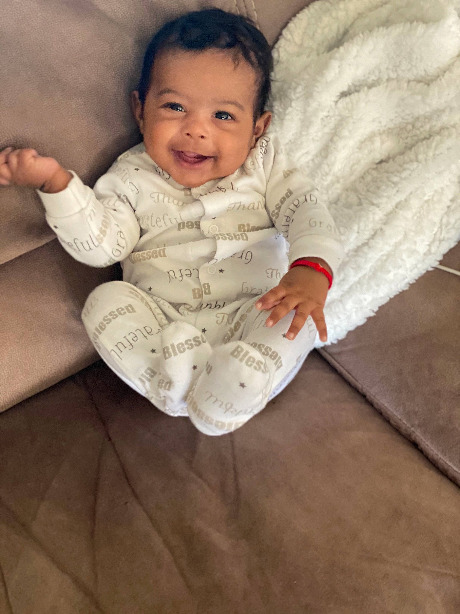 Hakeem is registered to the contest to win money with this photo: arm, baby, baby_toddler_clothing, comfort, eye, face, floor, flooring, happy, head, human_body, joy, linens, lip, nose, person, skin, sleeve, smile, t_shirt