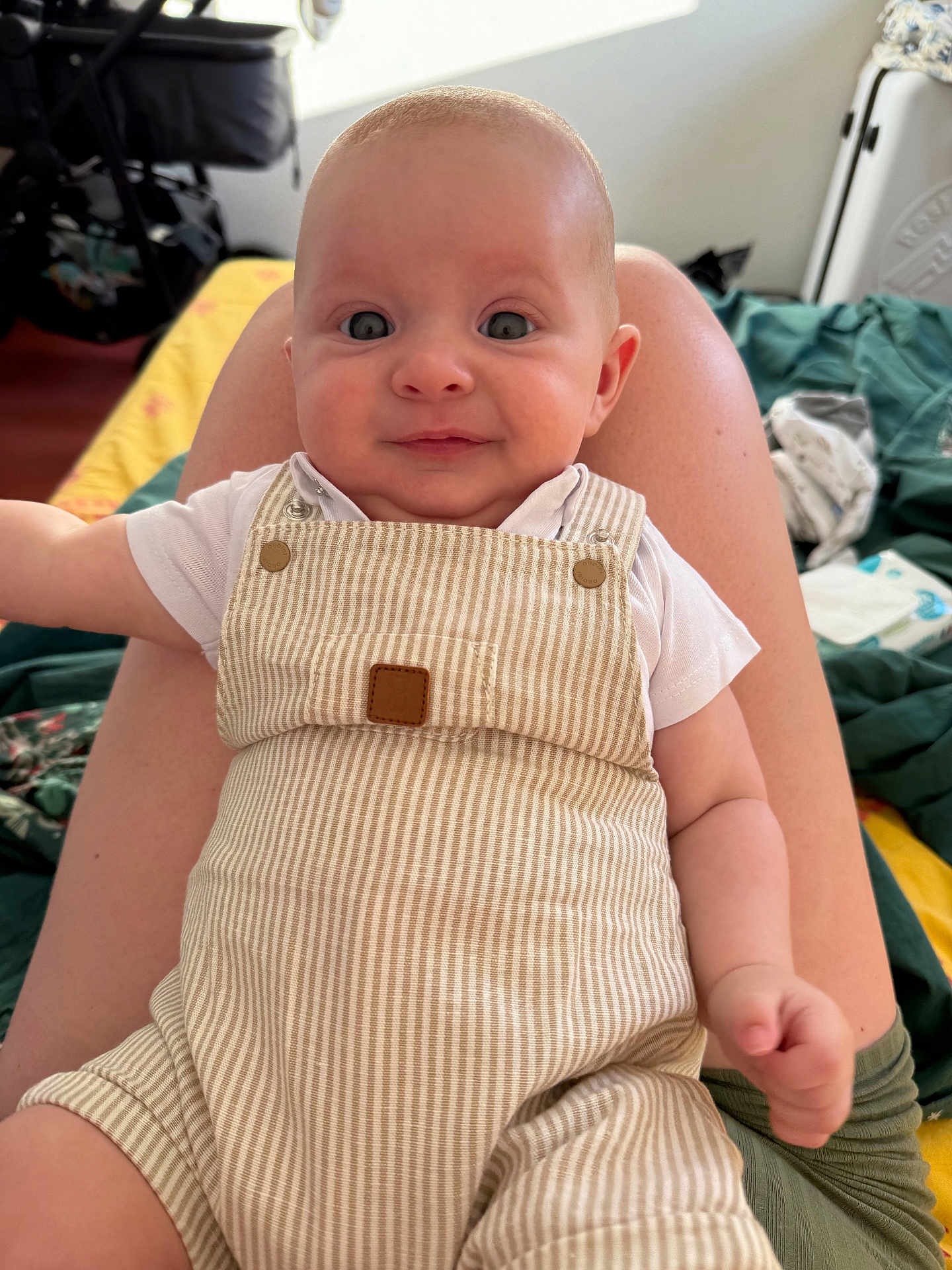Léandre a rejoint le concours — aidez-le/la à gagner de superbes lots ! baby, infant, child, overalls, striped_clothing, smile, face, eyes, skin, arm, hand, person, legs, lap, indoor, natural_light, cozy, casual, cute, portrait