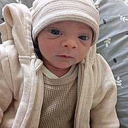 Eyden participe au concours pour gagner de l'argent avec cette photo : baby, infant, hat, beige_clothing, blanket, soft_fabric, face, eyes, newborn, closeup, cushion, patterned_background, portrait, cute, warm_clothing, child, indoors, sitting, cozy, small