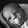 baby, pacifier, close_up, black_and_white, blanket, infant, face, eyes, newborn, child, portrait, soft, cute, sleepwear, head, warm, cozy, young, expression, peaceful