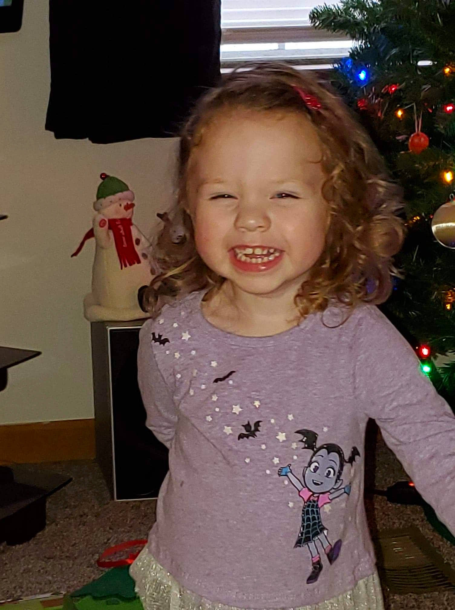 Lilian is registered to the contest to win money with this photo: baby_toddler_clothing, child, christmas, christmas_ornament, christmas_tree, event, eye, face, hairstyle, happy, holiday, human_body, iris, joy, person, pink, sleeve, smile, snapshot, standing