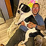 Porkchop Bishop joined the competition — help win amazing prizes! adult, beard, black_and_white_dog, casual_clothing, chair, dog, floor, glasses, hand, happy, home, indoor, man, patterned_fabric, pet, seated, smile, tattoo, watch, wooden_floor
