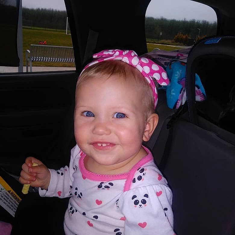 Leala is registered to the contest to win money with this photo: cap, car_seat, cheek, child, cool, day, ear, fashion_accessory, fun, girl, hair_accessory, head, headband, headgear, infant, joy, person, pink, product, skin