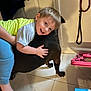 Oliver joined the competition — help win amazing prizes! child, dog, hugging, smiling, indoor, floor, tile, leash, clothing, person, pet, happy, young, light_hair, black_dog, footwear, door, toy, home, flooring