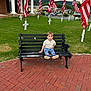 Oliver joined the competition — help win amazing prizes! child, bench, american_flag, grass, cross, brick_path, building, outdoor, person, sky, hill, flagpole, shoe, shirt, pants, nature, daylight, memorial, quiet, casual_clothing
