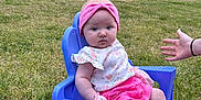 Laylah joined the competition — help win amazing prizes! baby, child, purple_chair, grass, outdoor, pink_headband, floral_top, pink_shorts, socks, hand, person, car, vehicle, trees, nature, daylight, cute, sitting, young_child, plastic_chair
