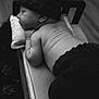 baby, newborn, infant, sleeping, black_and_white, knitted_hat, knitted_pants, tail, soft_surface, pillow, wooden_bed, peaceful, skin_folds, closeup, portrait, indoors, cute, resting, child, hat
