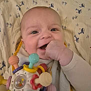 Naël a rejoint le concours — aidez-le/la à gagner de superbes lots ! baby, smiling, toy, hand, blanket, face, infant, chewing, clothing, pattern, closeup, child, cute, playful, indoor, happy, person, colorful, soft, lying