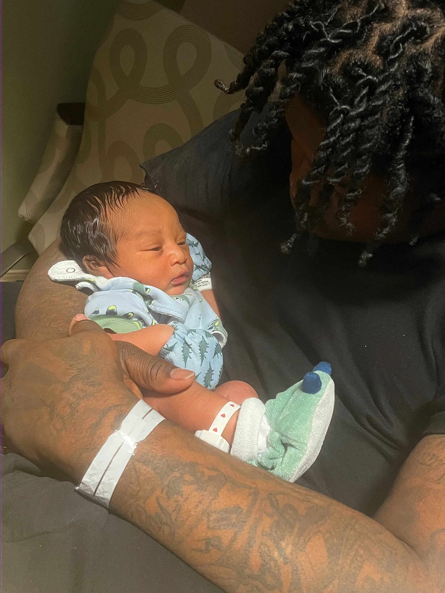 Kymier joined the competition — help win amazing prizes! newborn, baby, adult, tattoo, holding, sleeping, clothing, socks, hospital_bracelet, chair, arm, person, indoors, closeup, love, care, family, portrait, skin, hair