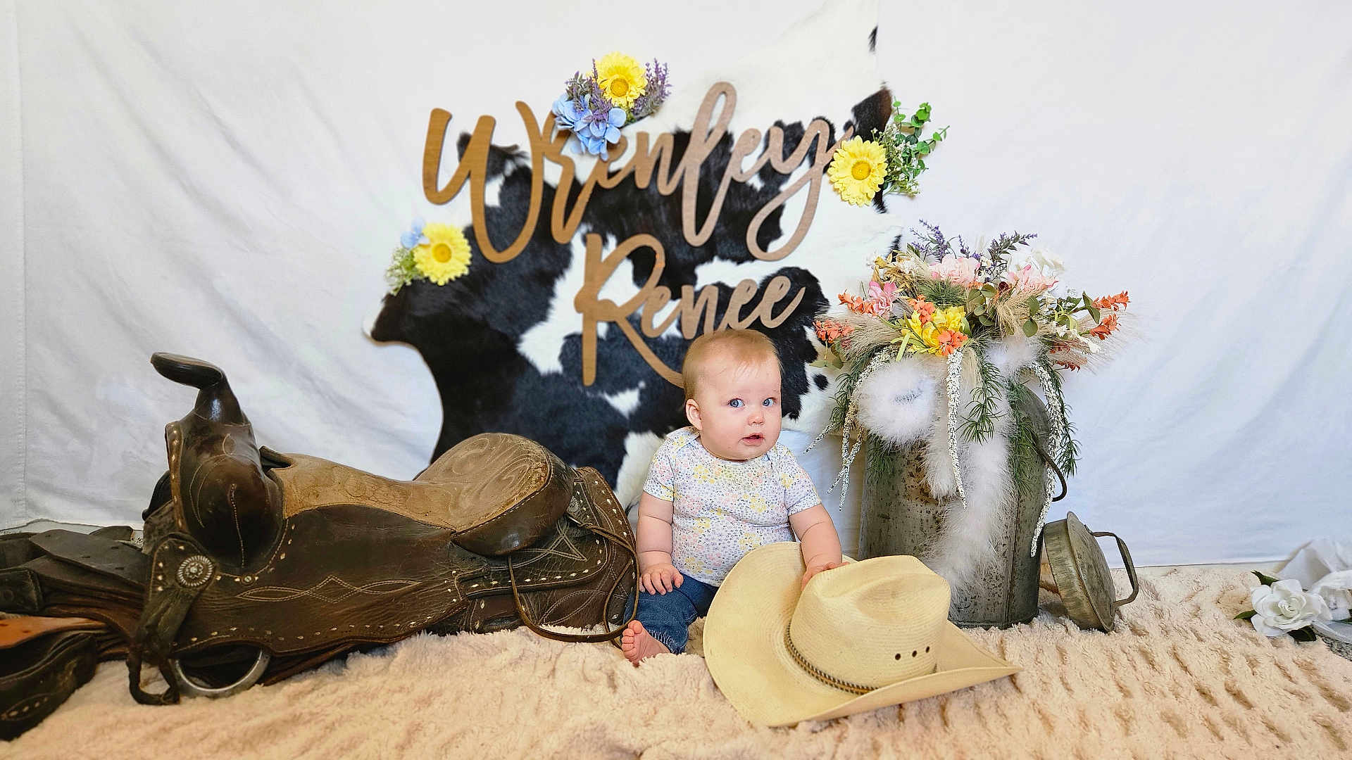 Wrenley joined the competition — help win amazing prizes! baby, cowhide, flowers, cowboy_hat, saddle, blanket, bucket, feathers, decor, blue_eyes, indoor, person, child, rustic, floral_arrangement, jeans, short_sleeve_shirt, name_sign, soft_texture, cute