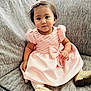 toddler, child, dress, pink, bow, couch, sofa, gold_shoes, hair_clip, indoor, cute, sitting, young_child, portrait, cozy, smiling, fashion, furniture, person, home