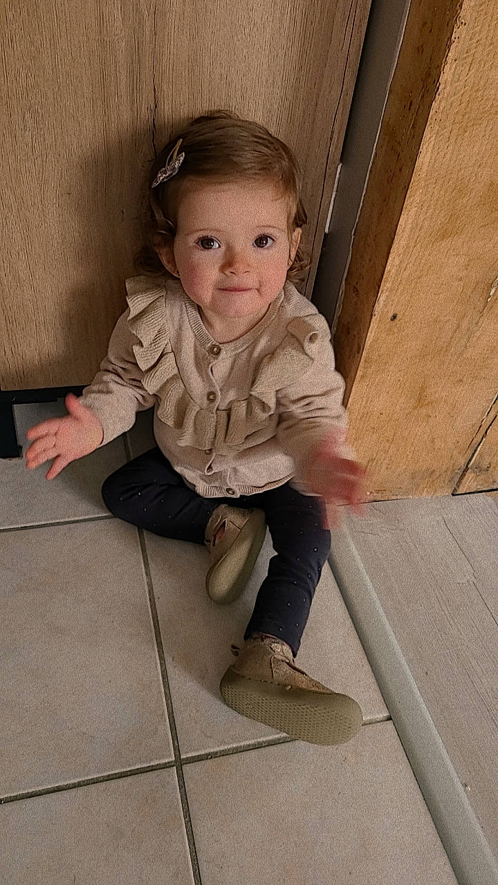 Tessa a rejoint le concours — aidez-le/la à gagner de superbes lots ! baby_toddler_clothing, cheek, child, dress, flash_photography, floor, flooring, foot, happy, hardwood, human_body, human_leg, person, shoe, sitting, sleeve, smile, stairs, standing, toddler