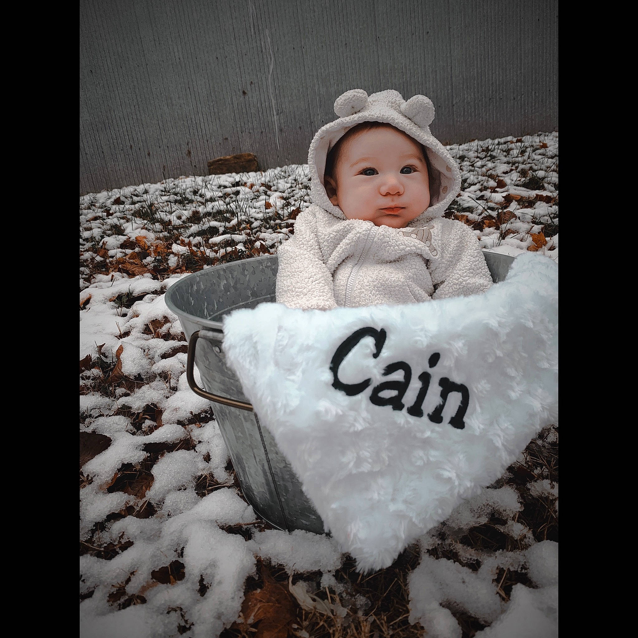 Cain is registered to the contest to win money with this photo: baby, baby_toddler_clothing, cap, cloud, dress, flash_photography, font, freezing, fur, grass, happy, headwear, monochrome_photography, people_in_nature, person, photo_caption, sitting, sky, sleeve, snow