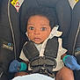 Andrea is registered to the contest to win money with this photo: baby, car_seat, infant, mittens, blanket, seatbelt, curly_hair, wide_eyes, child, safety, graco, blue, white, cute, indoors, portrait, young_child, clothing, seat, expression