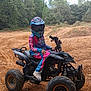 May Lynn participe au concours pour gagner de l'argent avec cette photo : active, adventure, atv, child, dirt, dirt_path, forest, helmet, helmet_visor, motocross_gear, nature, outdoor, person, riding, sport, tire, track, trees, vehicle, young
