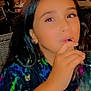 child, drink, straw, colorful_shirt, long_hair, indoor, restaurant, candid, face, person, table, glass, people, casual, dining, young, sitting, hair, blur, night