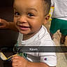 Kevin Davis joined the competition — help win amazing prizes! child, toddler, smile, indoor, couch, clothing, white_shirt, green_shorts, floor_tiles, playroom, alphabet_blocks, person, happy, cute, boy, short_hair, standing, two_children, casual_wear, daylight
