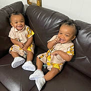 Kevin And Keldrick joined the competition — help win amazing prizes! toddlers, children, smiling, matching_outfits, sneakers, couch, indoor, happy, hair, clothing, person, seated, leather, brown, cute, playful, infant, two_people, young, casual