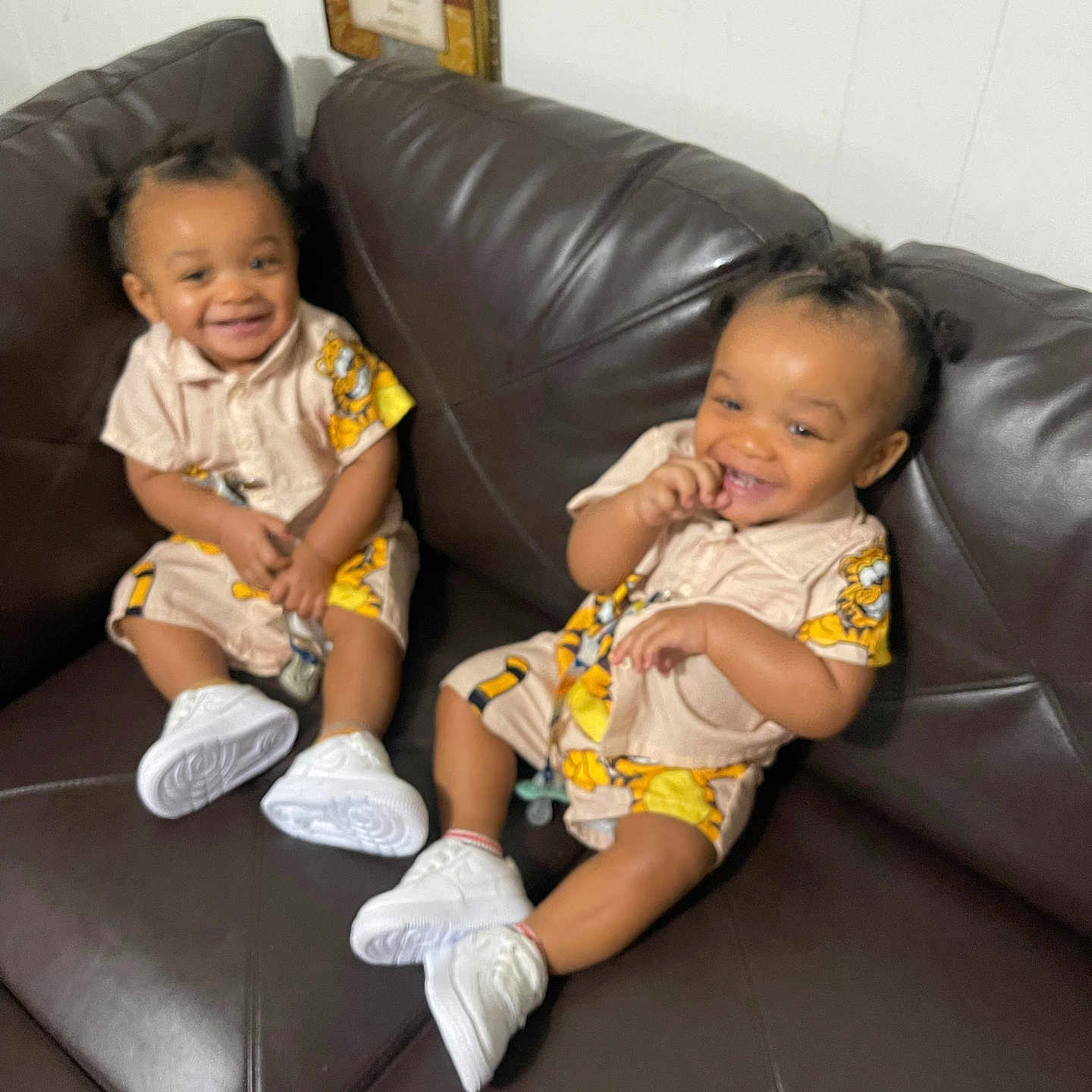 Kevin And Keldrick joined the competition — help win amazing prizes! toddlers, children, smiling, matching_outfits, sneakers, couch, indoor, happy, hair, clothing, person, seated, leather, brown, cute, playful, infant, two_people, young, casual