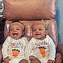 Kevin And Keldrick is registered to the contest to win money with this photo: baby, infant, child, smile, laugh, chair, clothing, onesie, headband, indoor, happy, person, two_children, cute, footwear, sock, wall_art, monkey, brown_chair, portrait