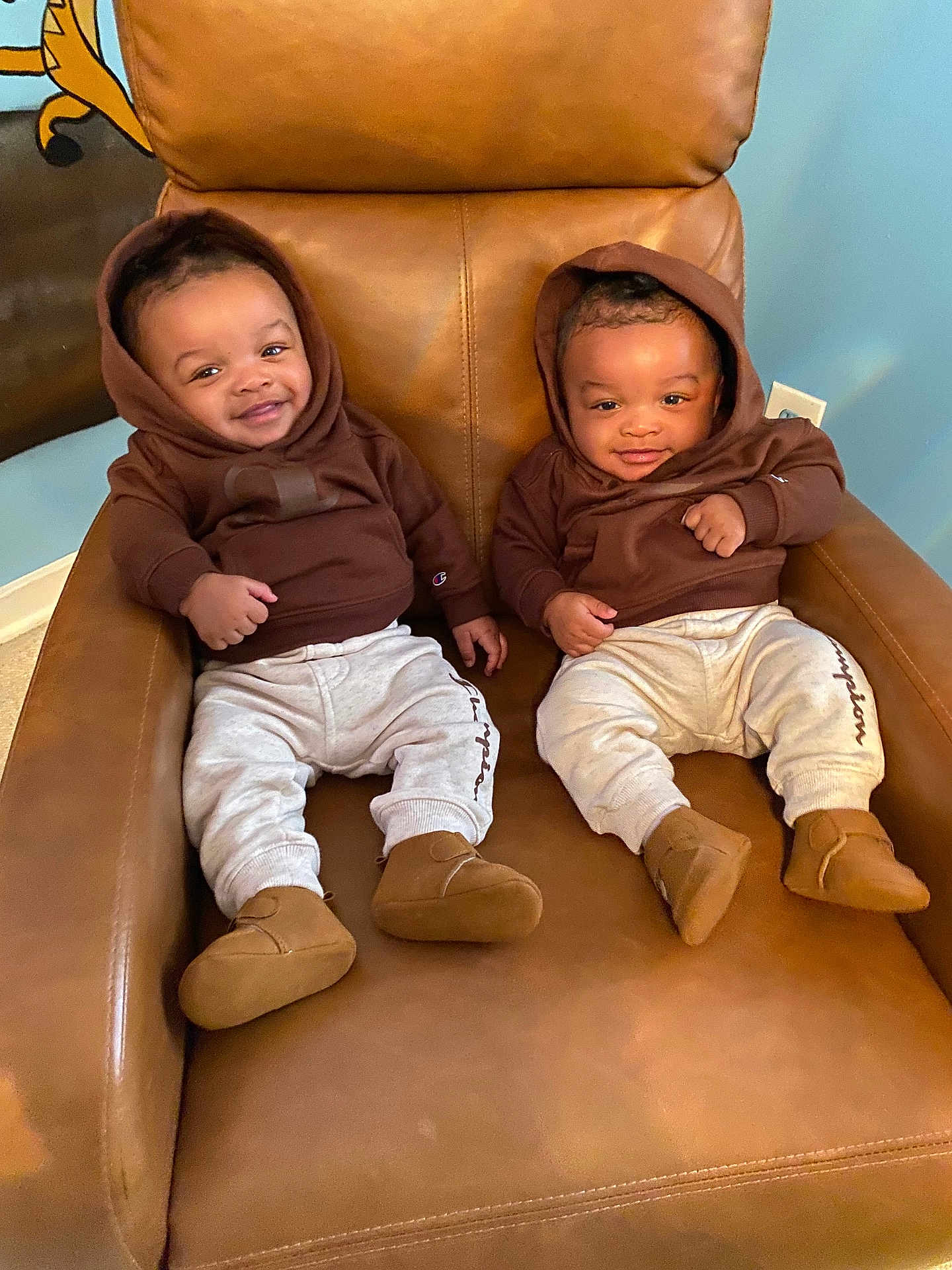 Kevin And Keldrick joined the competition — help win amazing prizes! baby, twins, smiling, hoodie, pants, shoes, chair, leather, indoor, cute, infant, child, matching_outfits, happy, sitting, portrait, person, cozy, home, relaxed