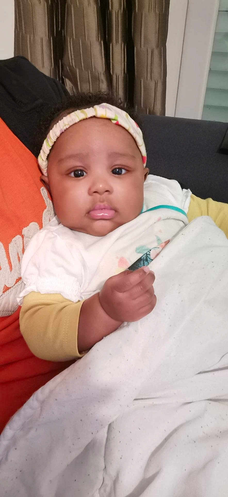 Shama Abigaelle participe au concours pour gagner de l'argent avec cette photo : baby, headband, blanket, person, child, face, indoor, couch, clothing, hand, curtain, portrait, expression, cozy, resting, young_child, skin, sleeve, comfort, seated