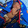 Julian is registered to the contest to win money with this photo: newborn, baby, sleeping, blanket, blue, diaper, bed, crib, striped_sheet, cartoon_characters, wooden_crib, infant, cozy, resting, child, indoors, peaceful, cute, soft, comfort