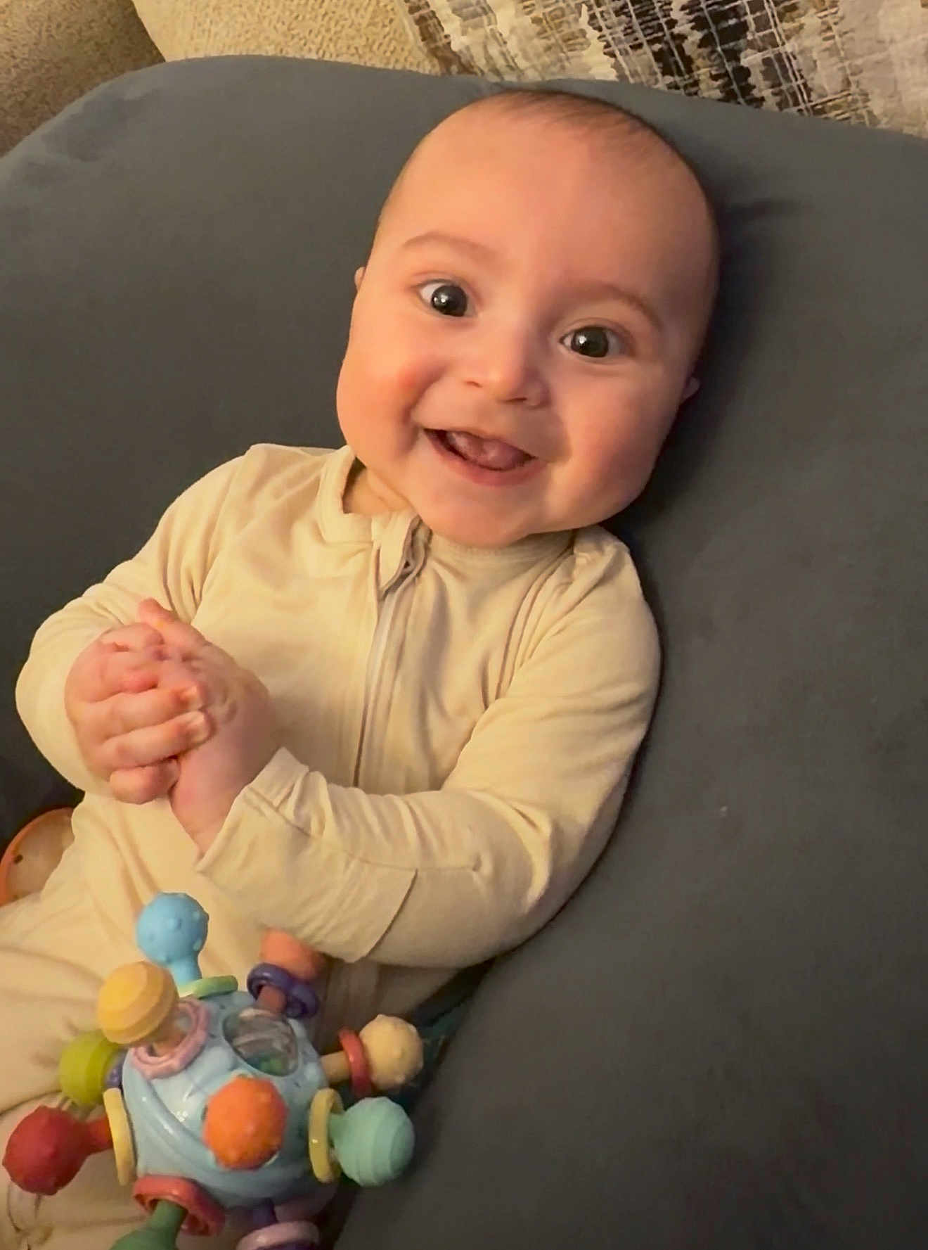 Grayson Harlo is registered to the contest to win money with this photo: baby, child, closeup, clothing, colorful, cushion, cute, expression, face, hand, happy, indoors, infant, joyful, person, playtime, portrait, smiling, soft, toy