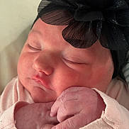 Emberlynn joined the competition — help win amazing prizes! newborn, baby, sleeping, headband, black_flower, hands, pink_clothing, close_up, face, infant, cute, soft_light, skin, portrait, peaceful, resting, child, young, indoors, cozy