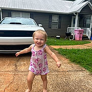 Emberly joined the competition — help win amazing prizes! toddler, child, barefoot, romper, pink, smiling, running, driveway, car, house, grass, outdoor, daytime, happy, person, clothing, window, door, grill, trash_bin