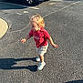 Emberly is registered to the contest to win money with this photo: toddler, child, asphalt, parking_lot, shadow, sunlight, red_tshirt, shorts, sneakers, vehicle, pickup_truck, outdoor, daylight, numbered_parking, walking, blond_hair, side_view, casual_clothing, young_child, playful