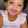 baby, child, infant, portrait, smiling, happy, tongue_out, curly_hair, brown_eyes, pink_clothing, cat_design, dress, sitting, indoor, close_up, face, head, adorable, photography, couch