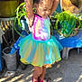 child, girl, tutu, dress, colorful, outdoor, plants, sunlight, smiling, pose, feet, sandals, hair_buns, concrete, potted_plants, greenery, summer, happy, playful, fashion