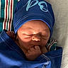 baby, blue_blanket, blue_hat, child, closeup, cozy, cute, face, hand, hospital_blanket, indoors, infant, newborn, peaceful, portrait, resting, sleeping, soft_light, striped_blanket, wrapped