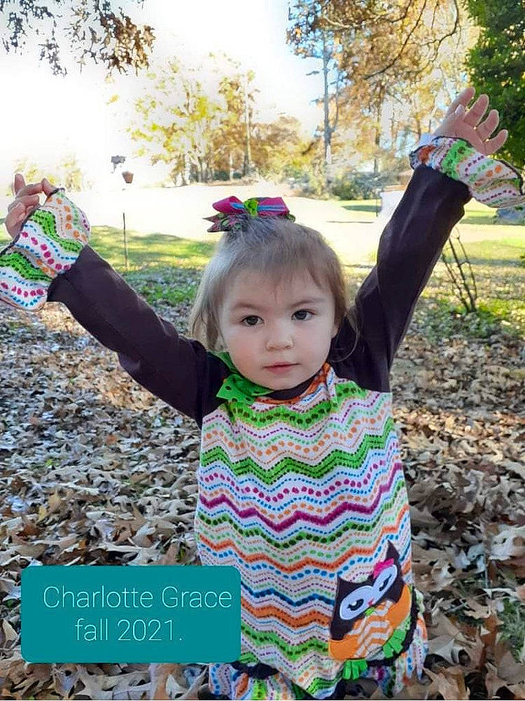 Charlotte Grace is registered to the contest to win money with this photo: arm, baby_toddler_clothing, child, finger, fun, grass, happy, leisure, pattern, people, people_in_nature, person, plant, product, recreation, sky, sleeve, spring, t_shirt, toddler
