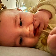 Carson joined the competition — help win amazing prizes! baby, infant, close_up, face, hand, fingers, lying_down, soft_lighting, curious, indoors, portrait, child, cute, expression, skin, young, person, sleepwear, cozy, blurred_background