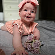 Leah is registered to the contest to win money with this photo: baby, child, smiling, pink_headband, pink_dress, flowers, roses, indoor, portrait, closeup, crawling, happy, cute, infant, hands, face, blue_eyes, soft_light, blanket, home
