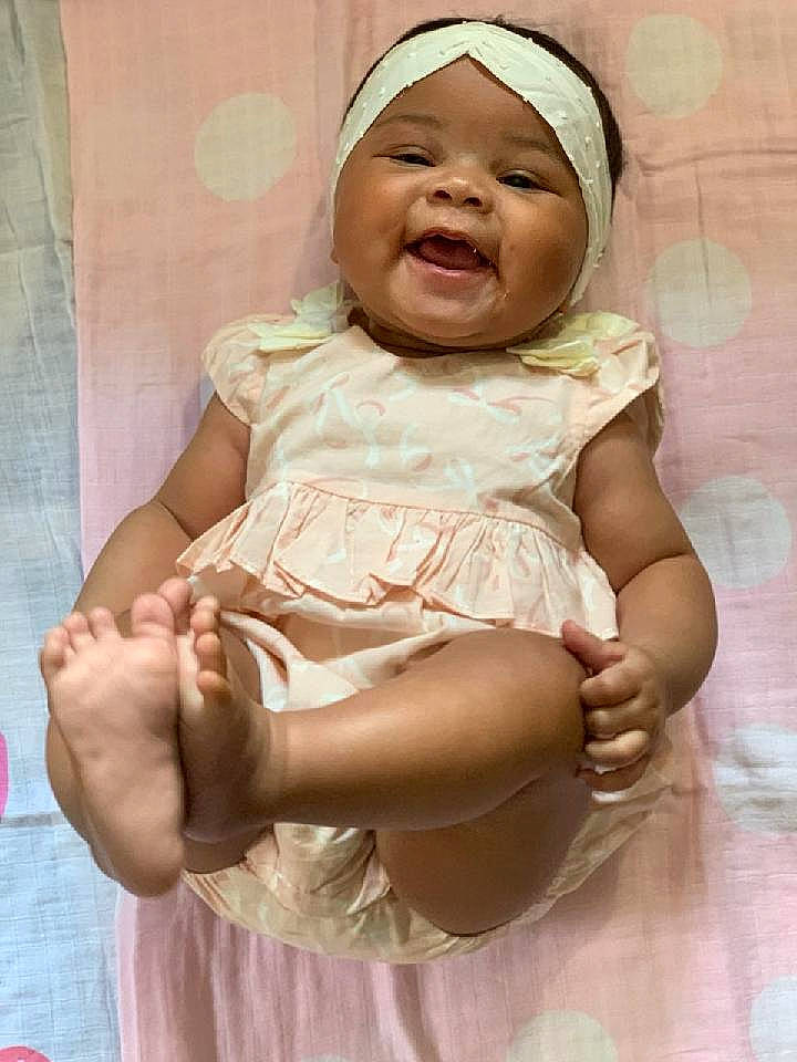 Eve is registered to the contest to win money with this photo: baby, baby_toddler_clothing, cheek, comfort, dress, event, finger, fun, gesture, hand, happy, hat, headwear, human_body, mouth, person, pink, skin, sleeve, smile