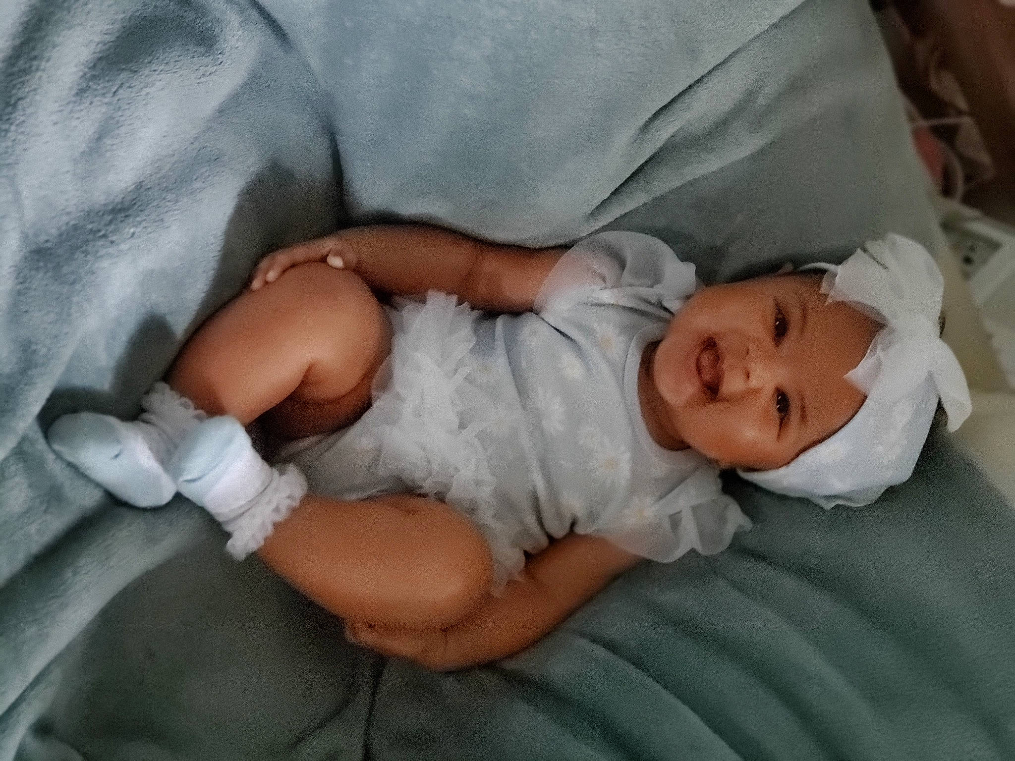 Eve is registered to the contest to win money with this photo: abdomen, baby, baby_products, baby_sleeping, baby_toddler_clothing, bedtime, child, comfort, elbow, finger, headwear, human_body, human_leg, knee, linens, person, sitting, skin, smile, textile