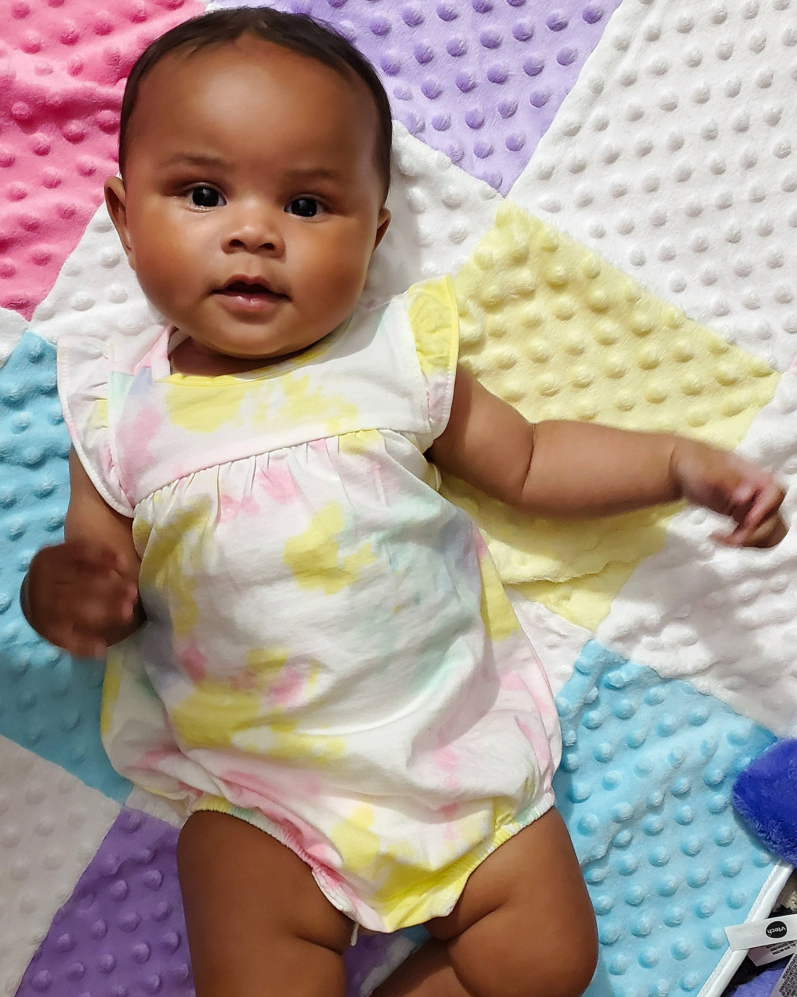 Eve is registered to the contest to win money with this photo: baby, baby_toddler_clothing, cheek, child, finger, fun, happy, human_leg, iris, linens, lip, magenta, nose, pattern, person, pink, purple, skin, sleeve, thigh