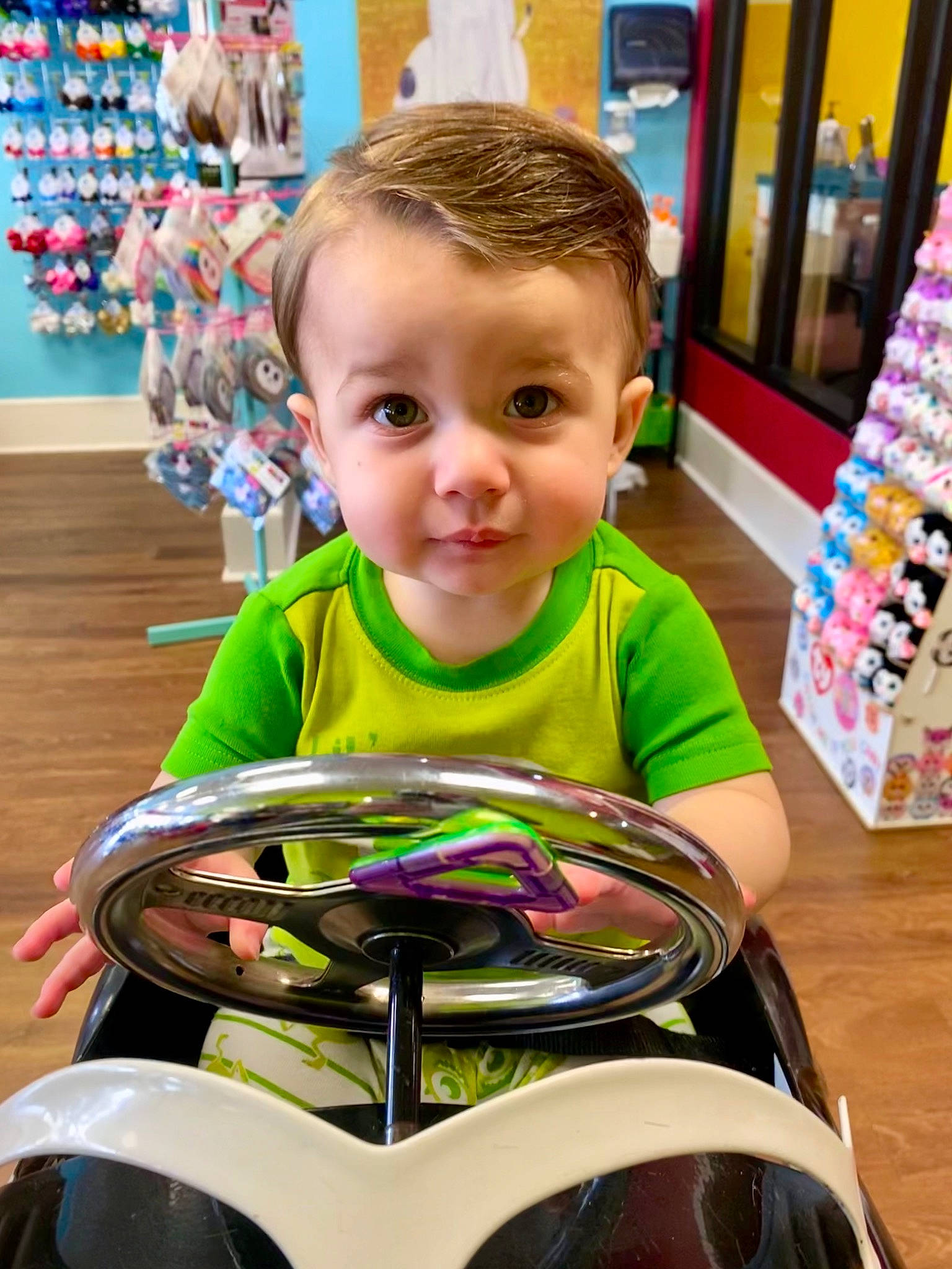 Greyson is registered to the contest to win money with this photo: automotive_design, baby, child, eye, eyewear, fun, happy, leisure, motorcycle_helmet, people, person, product, recreation, shirt, smile, snapshot, standing, t_shirt, toddler, vehicle