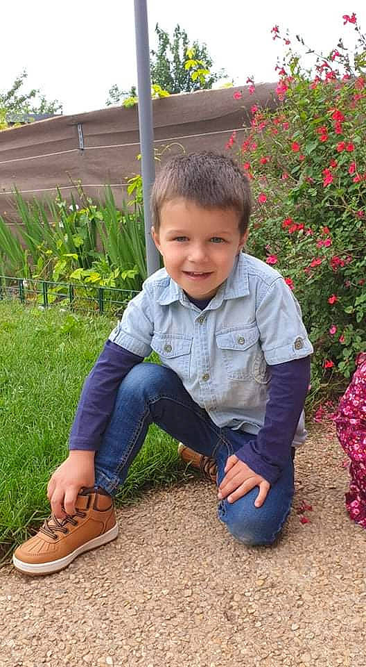 Enzo participe au concours pour gagner de l'argent avec cette photo : annual_plant, child, clothing, denim, flower, fun, grass, hairstyle, happy, joy, leisure, people_in_nature, person, plant, shoe, sitting, sky, sleeve, smile, standing