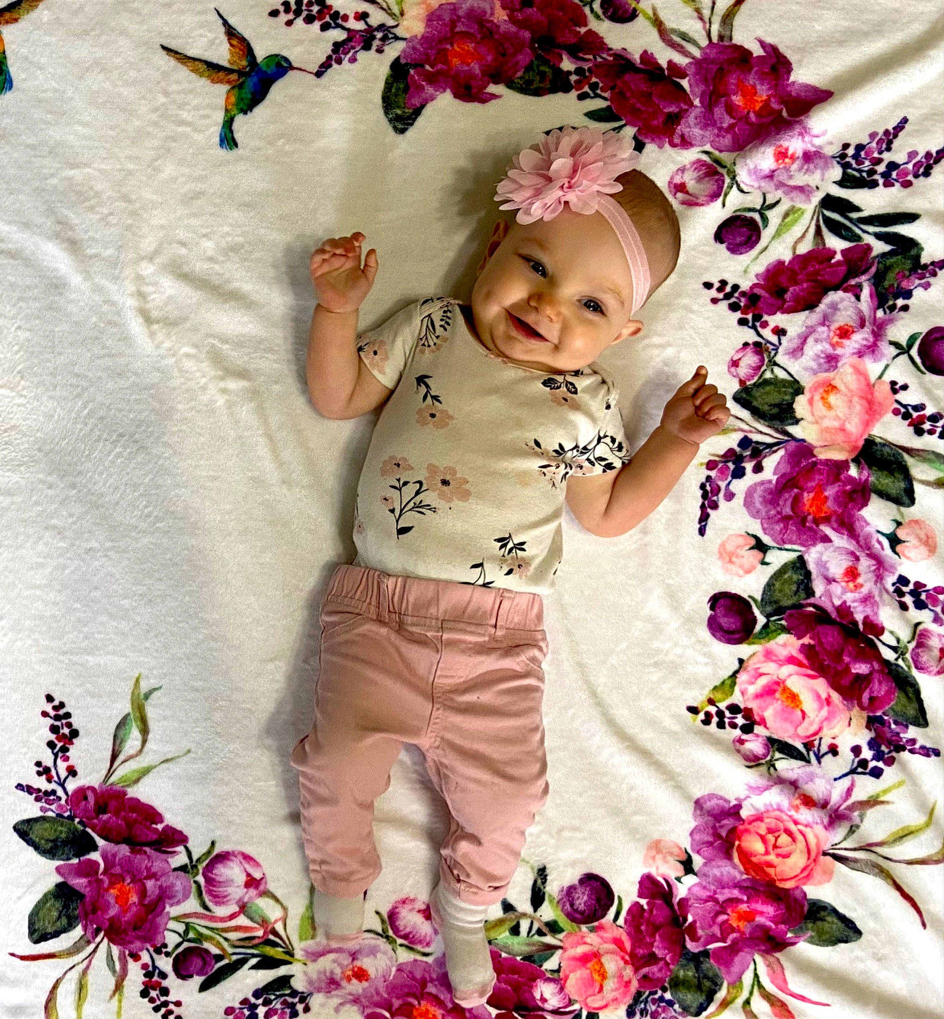 Sophia is registered to the contest to win money with this photo: baby_toddler_clothing, bouquet, child, cut_flowers, facial_expression, floral_design, flower, flower_arranging, happy, headwear, joy, magenta, pattern, people_in_nature, person, petal, pink, plant, sleeve, smile