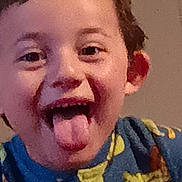 Dean is registered to the contest to win money with this photo: child, face, smiling, tongue_out, blue_clothing, cartoon_characters, onesie, indoor, playful, happy, cute, young, portrait, person, expression, funny_face, close_up, head, hair, eyebrows