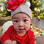 Thomas is registered to the contest to win money with this photo: baby, infant, child, red_clothing, hat, red_bow, christmas_tree, ornaments, christmas_lights, gift_wrap, floor, holiday, festive, indoors, cute, smiling, tongue_out, closeup, person, celebration