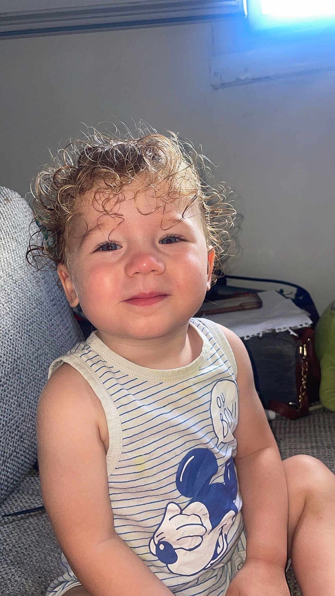 Ilan a rejoint le concours — aidez-le/la à gagner de superbes lots ! casual_clothing, child, couch, curly_hair, cute, happy, indoor, mickey_mouse, natural_light, person, portrait, relaxed, rosy_cheeks, sitting, smile, striped_clothing, tank_top, toddler, window_light, young_child