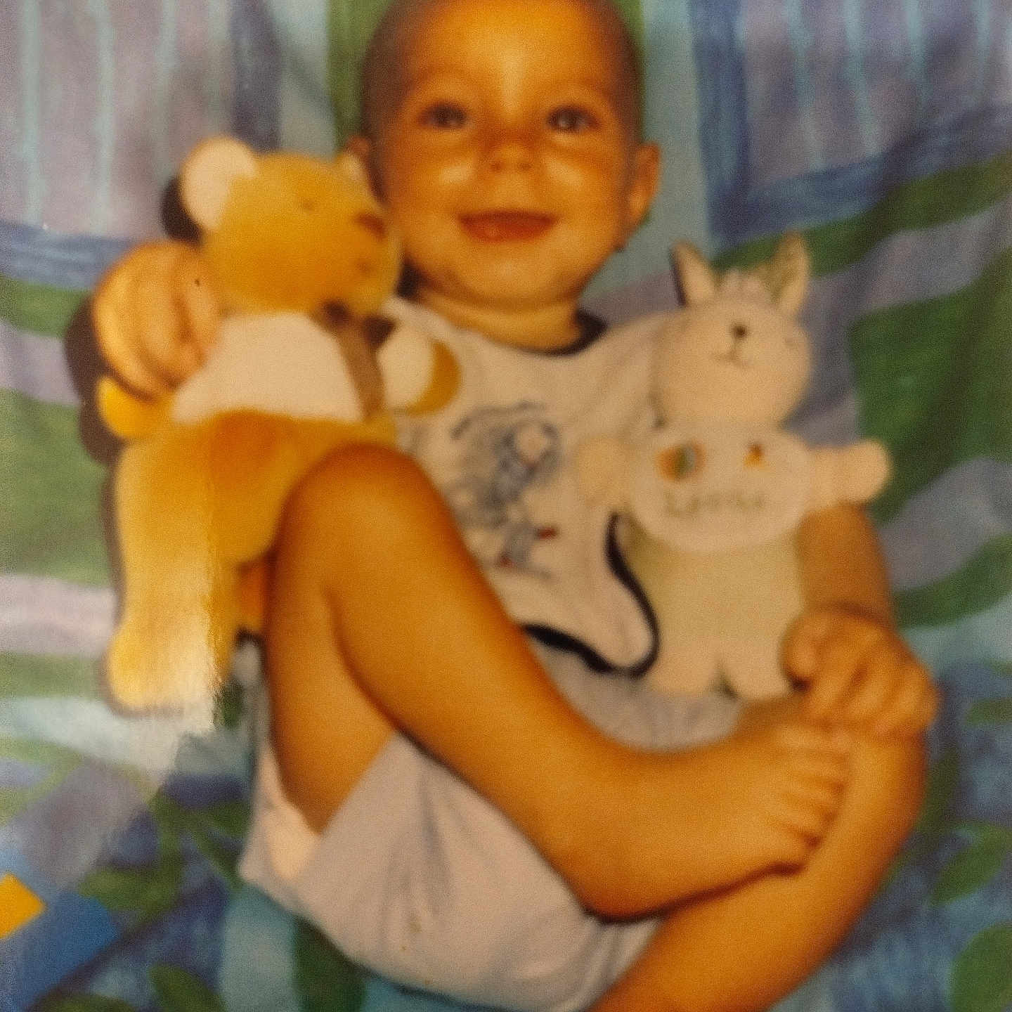 Emmanuel participe au concours pour gagner de l'argent avec cette photo : child, toddler, plush_toy, bear, bunny, smile, blanket, sitting, happy, indoor, cute, feet, clothing, toy, baby, portrait, infant, young_child, soft_toys, colorful_background
