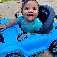 Ruemani joined the competition — help win amazing prizes! baby, child, smile, blue_toy_car, jeep, outdoor, grass, sidewalk, toy, happy, cute, play, infant, vehicle, wheel, greenery, daylight, joy, person, expression