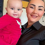 Kataleya a rejoint le concours — aidez-le/la à gagner de superbes lots ! baby, infant, woman, adult, person, smiling, portrait, selfie, indoor, red_shirt, black_shirt, holding, face, eyes, eyebrows, hand, boxes, stacked_boxes, makeup, cute